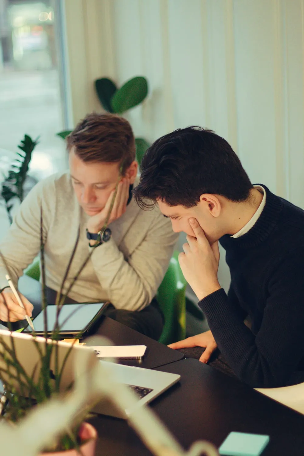 Two Enlight designers reviewing work on a tablet